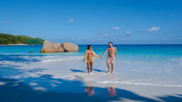 Тропічний острів Праслін Сейшельські острови з вітерними пляжами і пальмами, пара чоловіків і жінок середнього віку у відпустці на Сейшельських островах, які відвідують тропічний пляж Анс Лаціо Праслін Сейшельські острови — стокове фото