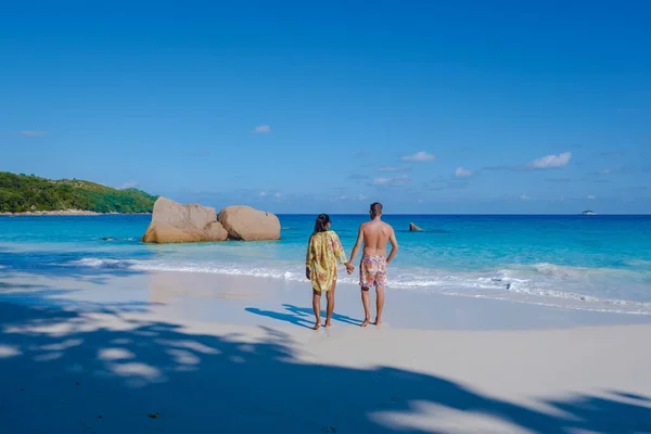 Praslin Seszele tropikalna wyspa z żwirowymi plażami i palmami, para mężczyzn i kobiet w średnim wieku na wakacjach na Seszelach zwiedzanie tropikalnej plaży Anse Lazio Praslin Seszele — Zdjęcie stockowe