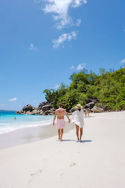 Praslin Σεϋχέλλες τροπικό νησί με παραλίες και φοίνικες, δύο άνδρες και γυναίκες μέσης ηλικίας για διακοπές στις Σεϋχέλλες που επισκέπτονται την τροπική παραλία του Anse Lazio Praslin Σεϋχέλλες — Φωτογραφία Αρχείου