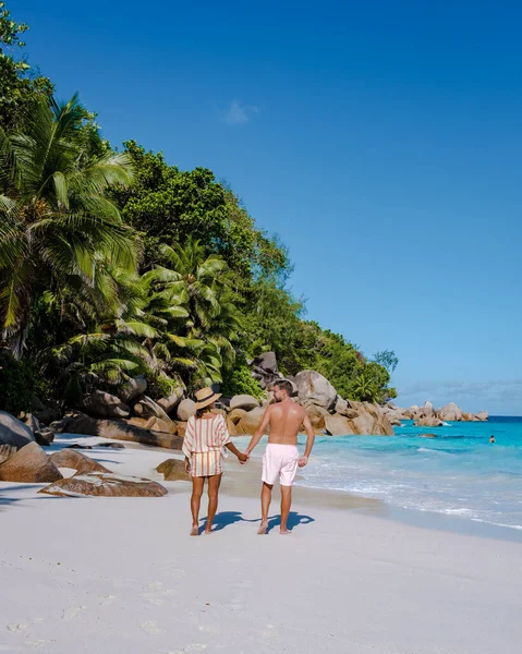 Praslin Seychelles isla tropical con playas y palmeras, pareja de hombres y mujeres de mediana edad de vacaciones en las Seychelles visitando la playa tropical de Anse Lazio Praslin Seychelles —  Fotos de Stock