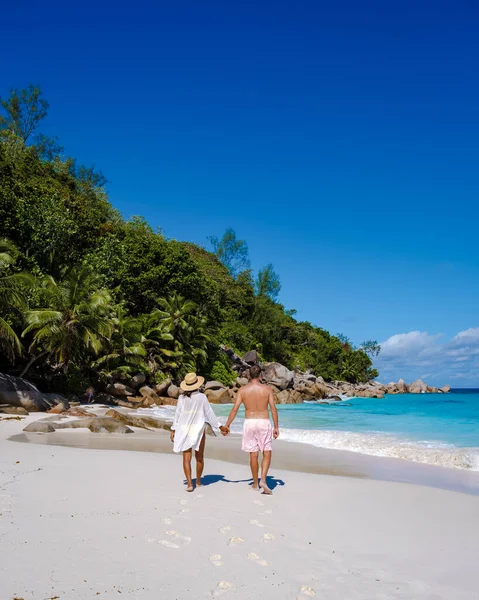 Praslin Seszele tropikalna wyspa z żwirowymi plażami i palmami, para mężczyzn i kobiet w średnim wieku na wakacjach na Seszelach zwiedzanie tropikalnej plaży Anse Lazio Praslin Seszele — Zdjęcie stockowe