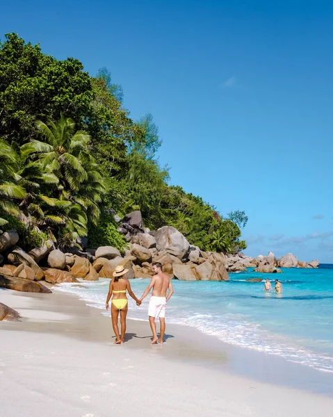Praslin Seyşeller tropikal adasında plajlar ve palmiye ağaçları var. Orta yaşlı birkaç erkek ve kadın tatilde Seyşeller 'de Anse Lazio Praslin Seyşeller' in tropik plajını ziyaret ediyor.