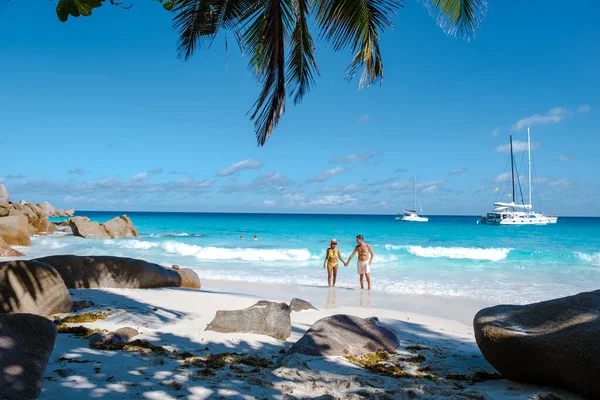 Praslin Seychelles tropical island with withe beaches and palm trees, couple men and women mid age on vacation at the Seychelles visiting the tropical beach of Anse Lazio Praslin Seychelles — ストック写真