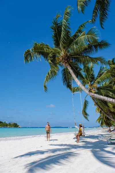 Praslin Seyşeller tropikal adasında, bilge plajlar ve palmiye ağaçları, hamakta sallanan bir çift erkek ve kadın Anse Volber Seyşeller 'deki bir palmiye ağacının altında.