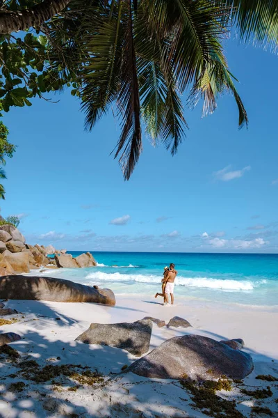 Praslin Seyşeller tropikal adasında plajlar ve palmiye ağaçları var. Orta yaşlı birkaç erkek ve kadın tatilde Seyşeller 'de Anse Lazio Praslin Seyşeller' in tropik plajını ziyaret ediyor.