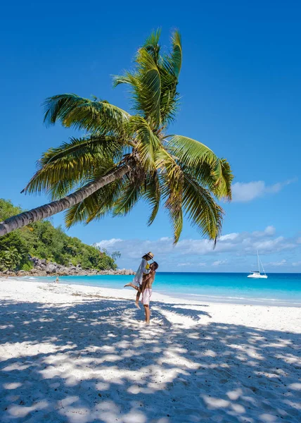 ビーチやヤシの木とプラスリンセイシェルの熱帯の島, Anseラツィオ・プラスリンセイシェルの熱帯のビーチを訪れるセーシェルで休暇中のカップルの男性と女性 — ストック写真