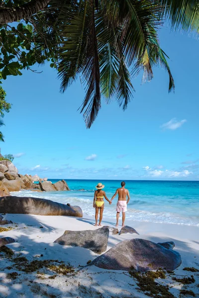 Praslin Seyşeller tropikal adasında plajlar ve palmiye ağaçları var. Orta yaşlı birkaç erkek ve kadın tatilde Seyşeller 'de Anse Lazio Praslin Seyşeller' in tropik plajını ziyaret ediyor.