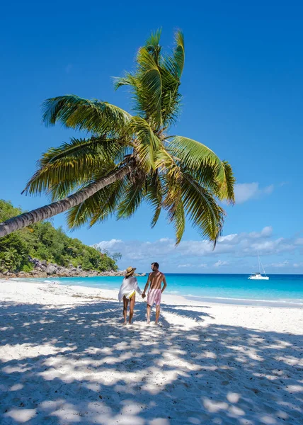 Isola tropicale di Praslin Seychelles con ampie spiagge e palme, coppia di uomini e donne di mezza età in vacanza alle Seychelles in visita alla spiaggia tropicale di Anse Lazio Praslin Seychelles — Foto Stock