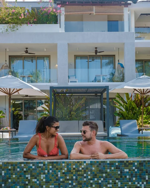 Praslin Seychelles, pareja de hombres y mujeres en la piscina durante sus vacaciones en un resort de lujo en la playa de Anse Volbert isla tropical con playas y palmeras, —  Fotos de Stock