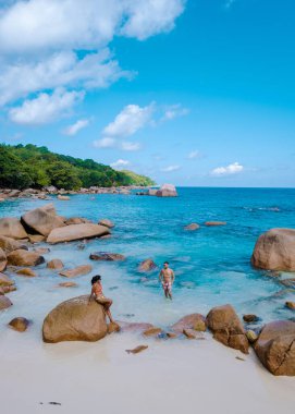 Praslin Seyşeller tropikal adasında plajlar ve palmiye ağaçları var. Orta yaşlı birkaç erkek ve kadın tatilde Seyşeller 'de Anse Lazio Praslin Seyşeller' in tropik plajını ziyaret ediyor.