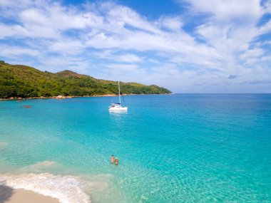 Praslin Seyşeller tropikal adasında plajlar ve palmiye ağaçları var. Seyşeller 'de tatilde olan iki erkek ve kadın. Anse Lazio Praslin Seyşeller' in tropik plajını ziyaret ediyorlar.. 