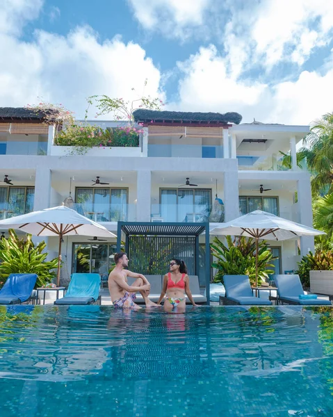 Praslin Seychelles, coppia di uomini e donne in piscina durante le vacanze in un resort di lusso sulla spiaggia di Anse Volbert isola tropicale con ampie spiagge e palme, — Foto Stock