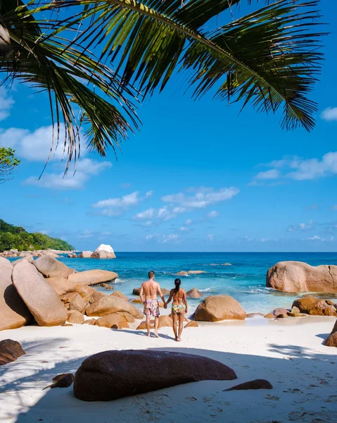 Praslin Σεϋχέλλες τροπικό νησί με παραλίες και φοίνικες, δύο άνδρες και γυναίκες μέσης ηλικίας για διακοπές στις Σεϋχέλλες που επισκέπτονται την τροπική παραλία του Anse Lazio Praslin Σεϋχέλλες — Φωτογραφία Αρχείου