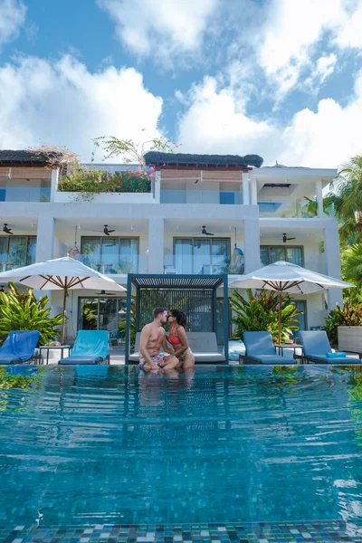 Praslin Seychelles, coppia di uomini e donne in piscina durante le vacanze in un resort di lusso sulla spiaggia di Anse Volbert isola tropicale con ampie spiagge e palme, — Foto Stock