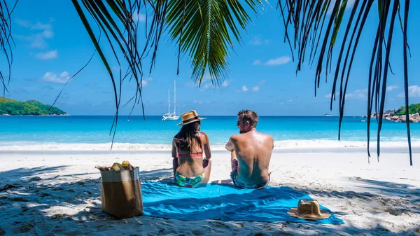 ビーチやヤシの木とプラスリンセイシェルの熱帯の島, Anseラツィオ・プラスリンセイシェルの熱帯のビーチを訪れるセーシェルで休暇中のカップルの男性と女性 — ストック写真