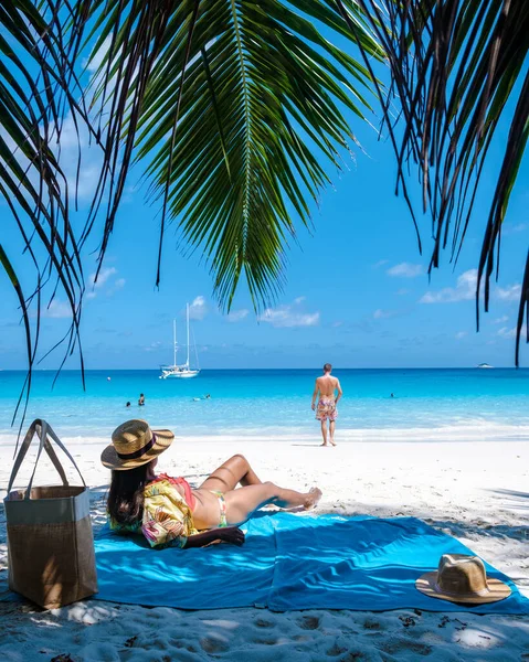 Praslin Seyşeller tropikal adasında plajlar ve palmiye ağaçları var. Seyşeller 'de tatilde olan iki erkek ve kadın. Anse Lazio Praslin Seyşeller' in tropik plajını ziyaret ediyorlar.. 