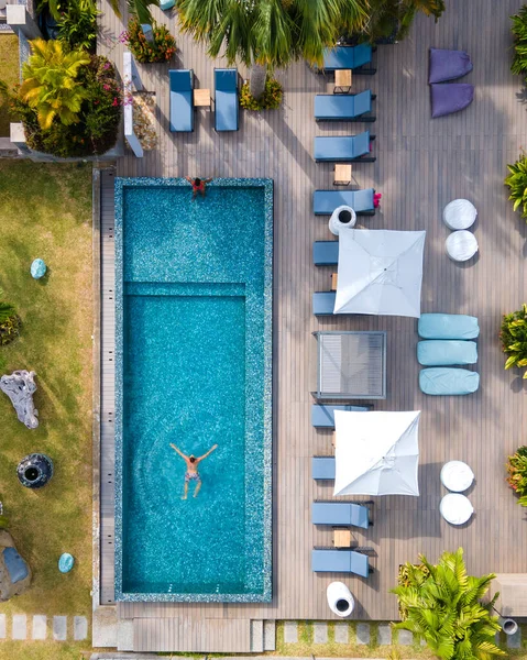 Bilardodan insansız hava aracı görüntüsü, Praslin Seyşeller, tatilde bilardo oynayan birkaç kadın ve erkek, Anse Volbert tropikal adasında plajları silip süpüren ve palmiye ağaçları olan lüks bir tatil köyünde.,