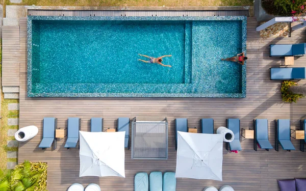 Drone vista aérea de abotve na piscina, Praslin Seychelles, casal de homens e mulheres na piscina durante as férias em um resort de luxo na praia de Anse Volbert ilha tropical com praias withe e palmeiras, — Fotografia de Stock
