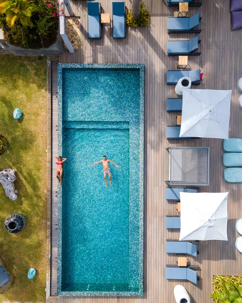 Drohnen-Luftaufnahme aus dem Pool, Praslin Seychellen, Paar Männer und Frauen im Pool im Urlaub in einem Luxus-Resort am Strand der tropischen Insel Anse Volbert mit weiten Stränden und Palmen, — Stockfoto
