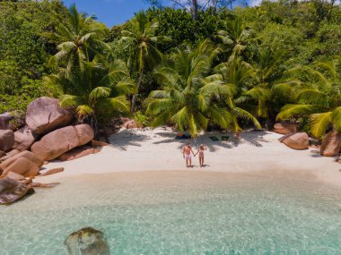 Praslin Seyşeller tropikal adası, plajları geniş ve palmiye ağaçları olan, orta yaşlı birkaç erkek ve kadın tatilde Seyşeller 'de tropikal Anse Lazio Praslin Seyşeller' in insansız hava aracı manzaralı plajını ziyaret ediyor.