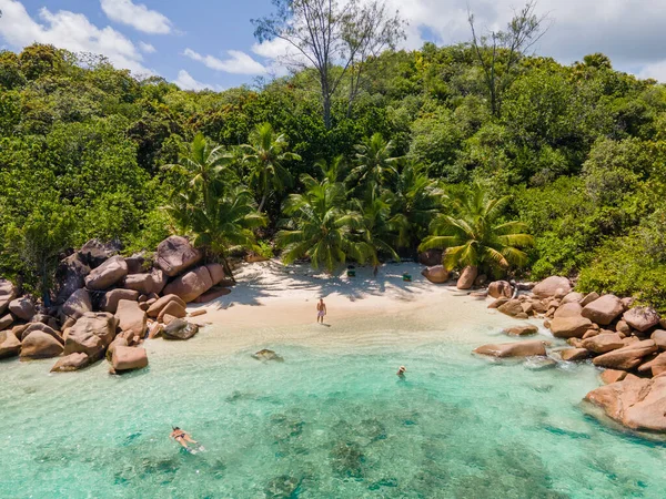 Praslin Seychelles tropical island with withe beaches and palm trees, couple men and women mid age on vacation at the Seychelles visiting the tropical beach of Anse Lazio Praslin Seychelles drone view — Stock Photo, Image