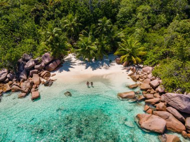 Praslin Seyşeller tropikal adası, plajları geniş ve palmiye ağaçları olan, orta yaşlı birkaç erkek ve kadın tatilde Seyşeller 'de tropikal Anse Lazio Praslin Seyşeller' in insansız hava aracı manzaralı plajını ziyaret ediyor.