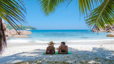Praslin Seyşeller tropikal adası, plajları geniş ve palmiye ağaçları olan, orta yaşlı birkaç erkek ve kadın tatilde Seyşeller 'de tropikal Anse Lazio Praslin Seyşeller' in insansız hava aracı manzaralı plajını ziyaret ediyor.