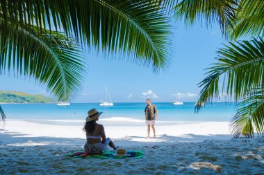 Praslin Seyşeller tropikal adası, plajları geniş ve palmiye ağaçları olan, orta yaşlı birkaç erkek ve kadın tatilde Seyşeller 'de tropikal Anse Lazio Praslin Seyşeller' in insansız hava aracı manzaralı plajını ziyaret ediyor.