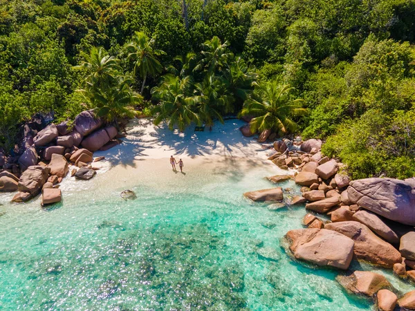 Isola tropicale di Praslin Seychelles con ampie spiagge e palme, coppia di uomini e donne di mezza età in vacanza alle Seychelles visitando la spiaggia tropicale di Anse Lazio — Foto Stock