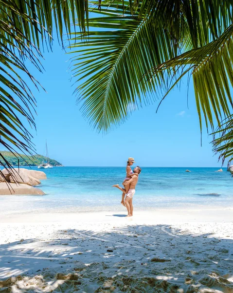 Isola tropicale di Praslin Seychelles con ampie spiagge e palme, coppia di uomini e donne di mezza età in vacanza alle Seychelles visitando la spiaggia tropicale di Anse Lazio — Foto Stock