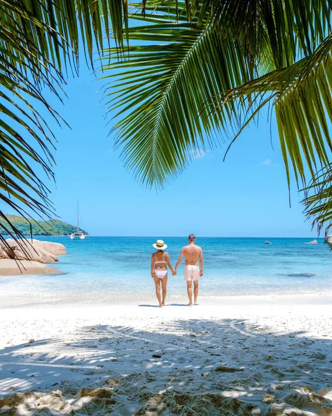 Praslin Seyşeller tropikal adası, plajları geniş ve palmiye ağaçları olan, orta yaşlı birkaç erkek ve kadın tatilde Seyşeller 'de tropikal Anse Lazio Praslin Seyşeller' in insansız hava aracı manzaralı plajını ziyaret ediyor.