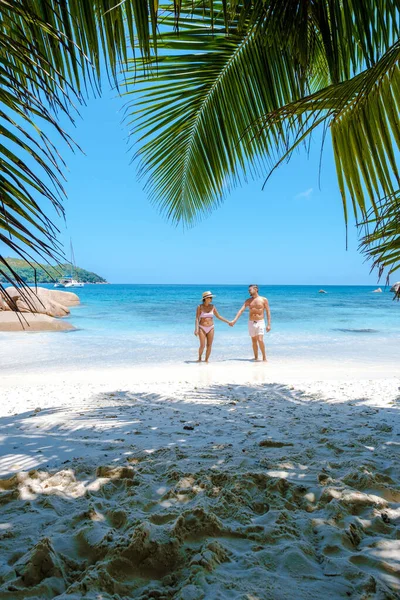 Praslin Σεϋχέλλες τροπικό νησί με παραλίες withe και φοίνικες, ζευγάρι άνδρες και γυναίκες μέσης ηλικίας για διακοπές στις Σεϋχέλλες επισκέπτονται την τροπική παραλία του Anse Lazio Praslin Σεϋχέλλες drone view — Φωτογραφία Αρχείου