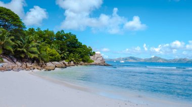 Anse Patates beach, La Digue Island, Seyshelles, white beach with blue ocean and palm trees