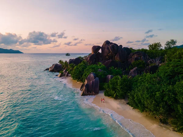Anse Source dArgent beach, La Digue Island, Seyshelles, Drone aerial view of La Digue Seychelles bird eye view, couple men and woman walking at the beach during sunset at a luxury vacation — Stockfoto