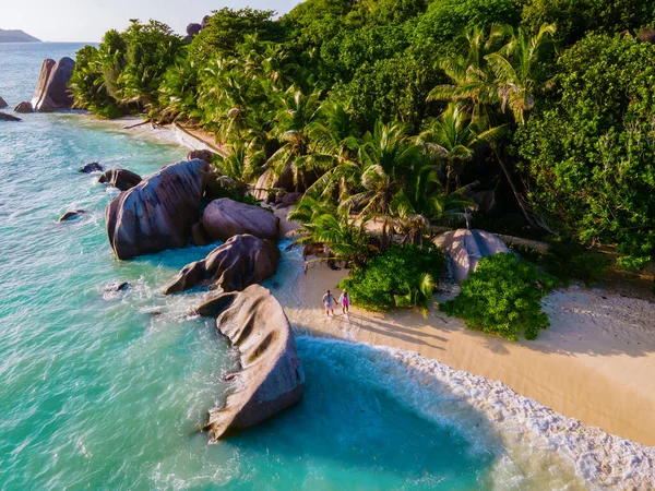 Anse Source dArgent beach, La Digue Island, Seyshelles, Drone aerial view of La Digue Seychelles bird eye view, couple men and woman walking at the beach during sunset at a luxury vacation — Stockfoto