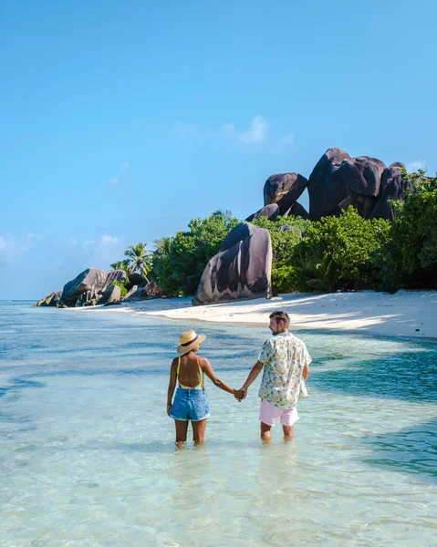 Anse Source dArgent plajı, La Digue Adası, Seyshelles, İHA hava görüntüsü La Digue Seyşelles kuş bakışı, gün batımında sahilde yürüyen birkaç erkek ve kadın lüks bir tatilde