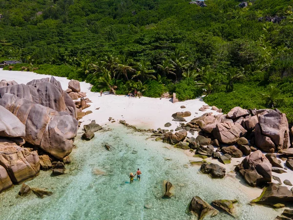 Anse Cocos beach, La Digue Island, Seyshelles, Drone vista aerea di La Digue Seychelles vista a volo d'uccello, coppia di uomini e donne che camminano in spiaggia durante il tramonto in una vacanza di lusso — Foto Stock