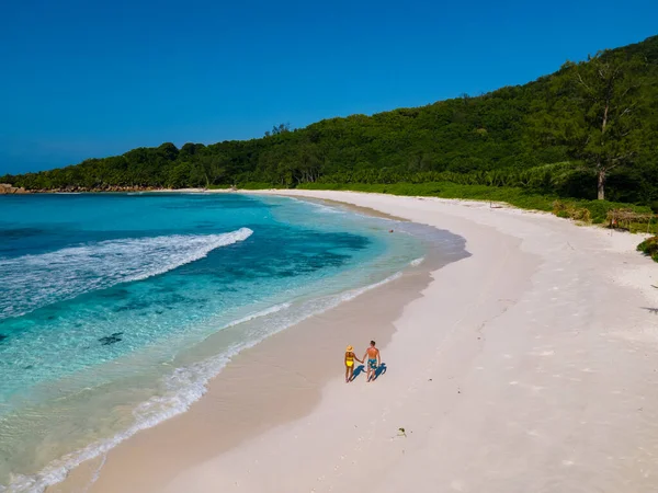 Anse Cocos plaża, La Digue Island, Seyshelles, Drone widok z lotu ptaka La Digue Seszele, para mężczyzn i kobiet spacerujących po plaży podczas zachodu słońca na luksusowych wakacjach — Zdjęcie stockowe