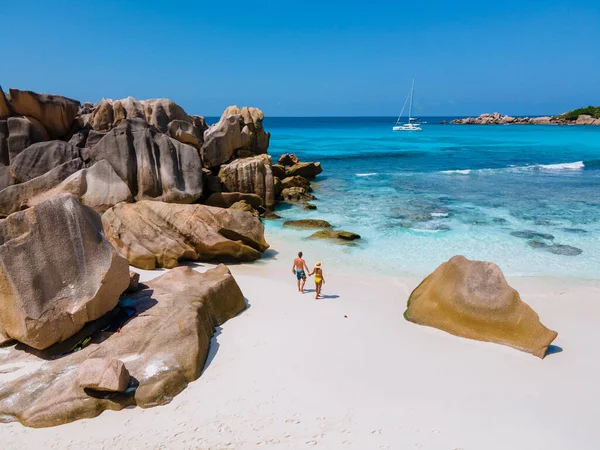 Anse Cocos παραλία, La Digue Island, Seyshelles, Drone εναέρια άποψη της La Digue Σεϋχέλλες πουλί θέα, ζευγάρι άνδρες και γυναίκες με τα πόδια στην παραλία κατά τη διάρκεια του ηλιοβασιλέματος σε πολυτελείς διακοπές — Φωτογραφία Αρχείου