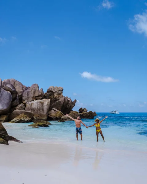 Anse Cocos παραλία, La Digue Island, Seyshelles, Drone εναέρια άποψη της La Digue Σεϋχέλλες πουλί θέα, ζευγάρι άνδρες και γυναίκες με τα πόδια στην παραλία κατά τη διάρκεια του ηλιοβασιλέματος σε πολυτελείς διακοπές — Φωτογραφία Αρχείου