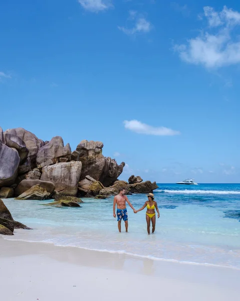 Anse Cocos海滩、 La Digue岛、 Seyshelles 、 Drone鸟瞰La Digue塞舌尔的鸟瞰景观，一对男女在日落时在海滩上散步，享受奢华假期 — 图库照片
