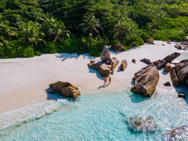 Anse Cocos beach, La Digue Island, Seyshelles, Drone aerial view of La Digue Seychelles bird eye view, couple men and woman walking at the beach during sunset at a luxury vacation — Zdjęcie stockowe
