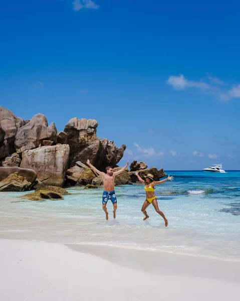Anse Cocos plajı, La Digue Adası, Seyshelles, La Digue Seychelles kuş bakışı drone görüntüsü, günbatımında kumsalda yürüyen birkaç erkek ve kadın lüks bir tatilde.