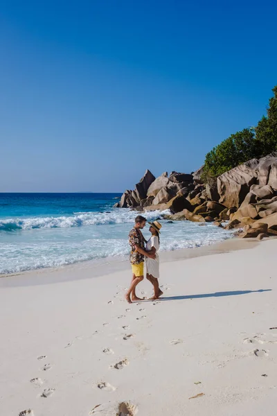 Anse Cocos plajı, La Digue Adası, Seyshelles, La Digue Seychelles kuş bakışı drone görüntüsü, günbatımında kumsalda yürüyen birkaç erkek ve kadın lüks bir tatilde. — Stok fotoğraf
