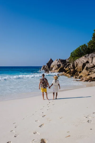 Anse Cocos beach, La Digue Island, Seyshelles, Drone letecký pohled na La Digue Seychelles pohled z ptačí perspektivy, pár mužů a žen kráčejících na pláži při západu slunce při luxusní dovolené — Stock fotografie