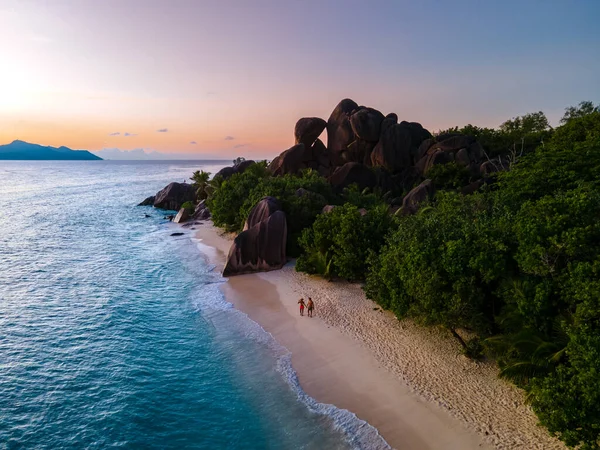 Anse Source dArgent beach, La Digue Island, Seyshelles, Drone vista aerea di La Digue Seychelles bird eye view, coppia di uomini e donne che camminano in spiaggia durante il tramonto in una vacanza di lusso — Foto Stock