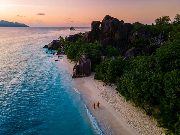 Anse Source dArgent beach, La Digue Island, Seyshelles, Drone vista aerea di La Digue Seychelles bird eye view, coppia di uomini e donne che camminano in spiaggia durante il tramonto in una vacanza di lusso — Foto Stock