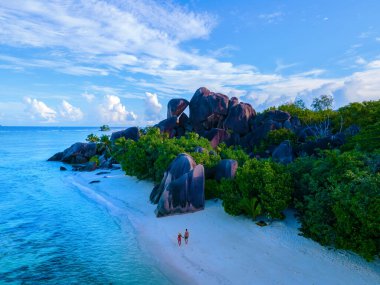 Anse Source dArgent beach, La Digue Island, Seyshelles, Drone aerial view of La Digue Seychelles bird eye view, couple men and woman walking at the beach during sunset at a luxury vacation clipart