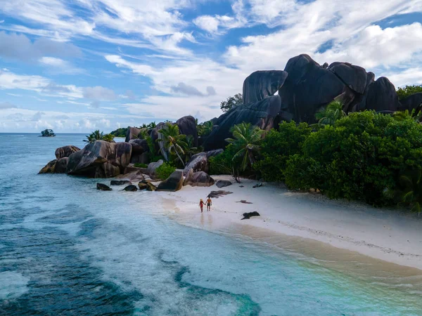 Anse Source dArgent beach, La Digue Island, Seyshelles, Drone aerial view of La Digue Seychelles bird eye view, couple men and woman walking at the beach during sunset at a luxury vacation — стоковое фото
