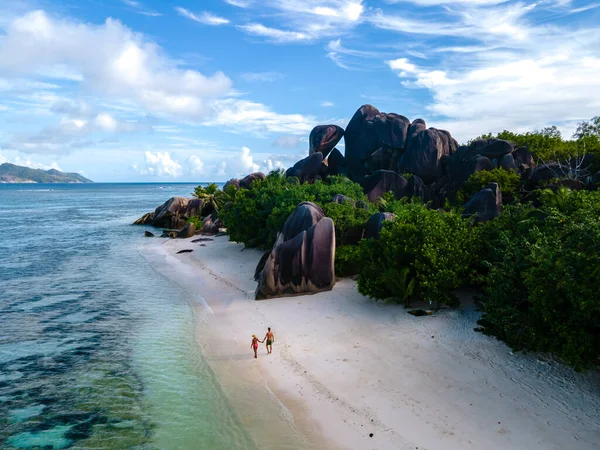 Anse Source dArgent beach, La Digue Island, Seyshelles, Drone vista aerea di La Digue Seychelles bird eye view, coppia di uomini e donne che camminano in spiaggia durante il tramonto in una vacanza di lusso — Foto Stock